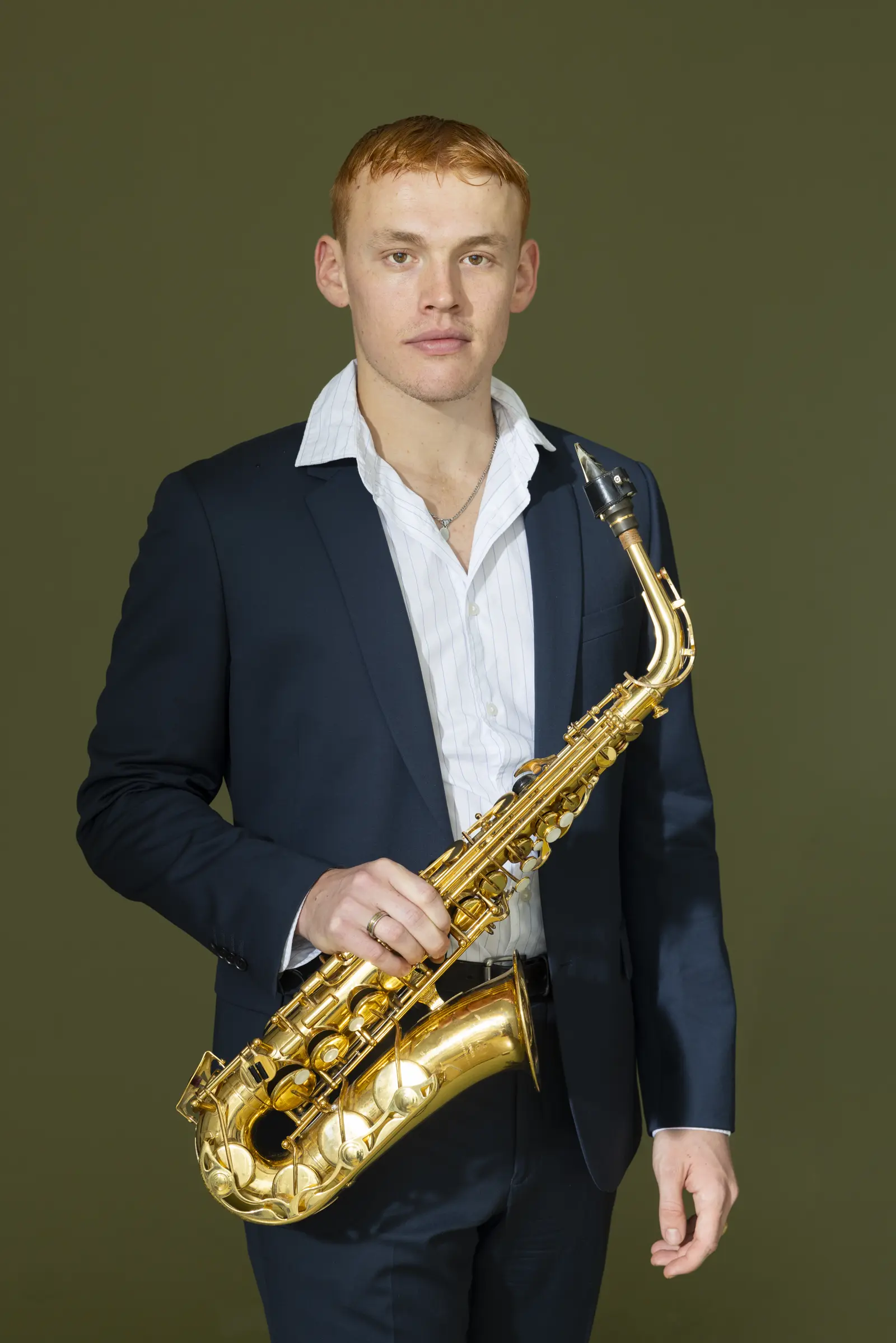 Hélion Sax, saxophoniste de mariage, en veste de costume avec son saxophone alto, qui a joué à l'Abbaye des Vaux de Cernay
